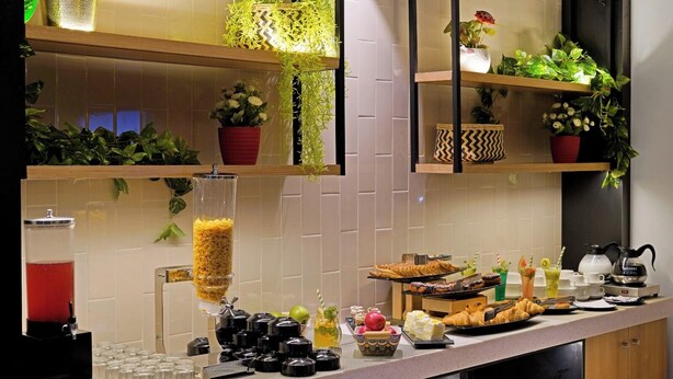 Montaje de bufé con diferentes alimentos y dispensador de bebidas.