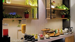 Montaje de bufé con diferentes alimentos y dispensador de bebidas.