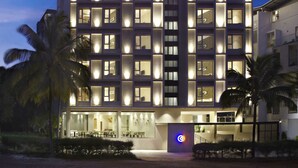 Un hotel de varios pisos con ventanas iluminadas y un llamativo letrero de 'Click Hotels'.
