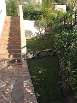 Stroll through a serene garden with a stone staircase, lush greenery, and an atmosphere.