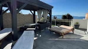 A rooftop terrace with a pergola, lounge chairs, and a table. - Villa with swimming pool and directly by the sea on the Rte des Sanguinaires (Ajaccio)