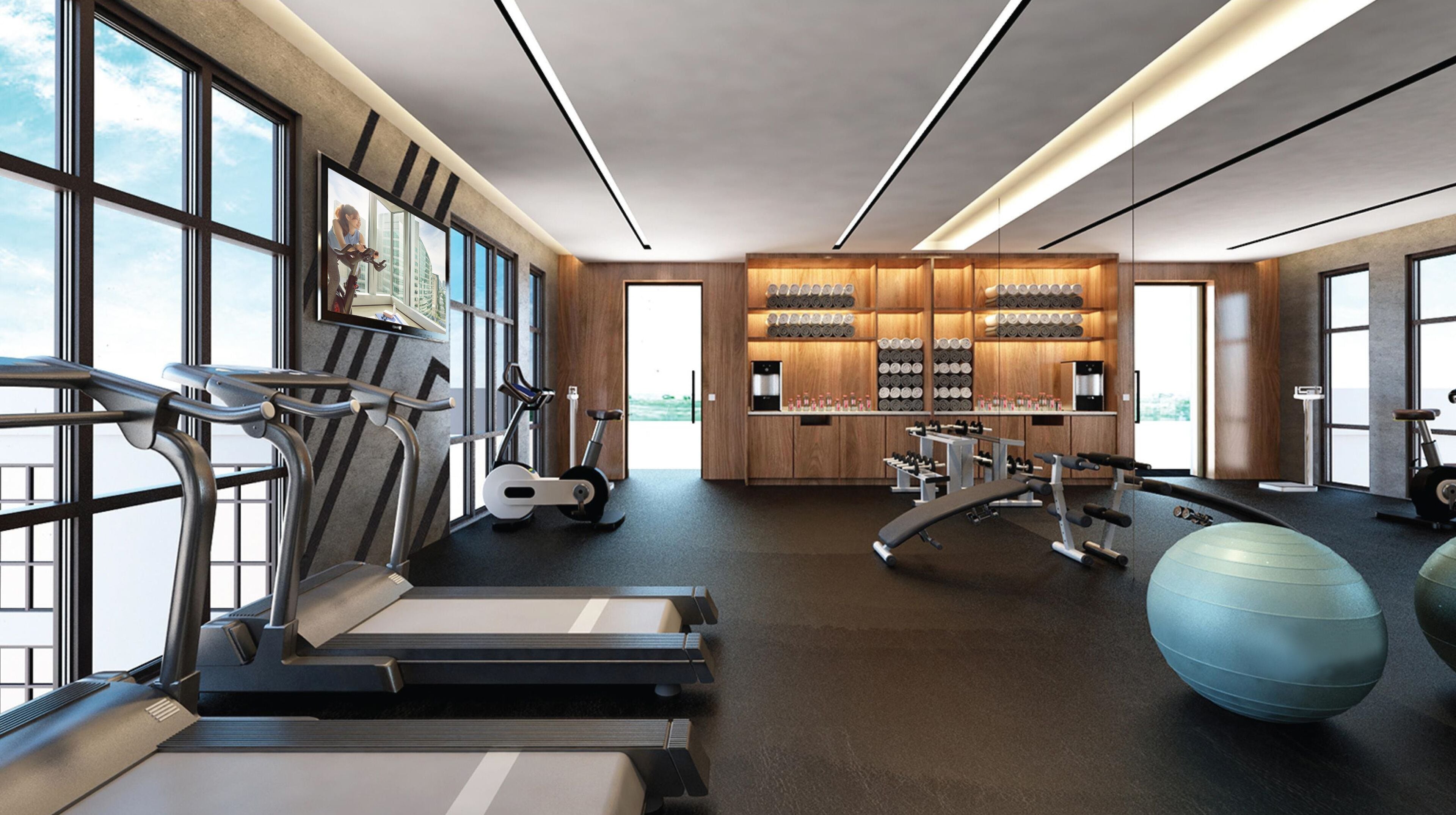 A modern gym with treadmills, exercise bikes, and free weights.
