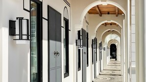 A corridor with a patterned floor, white walls, and black-framed doors. - Citadines Connect Georgetown Penang (George Town)