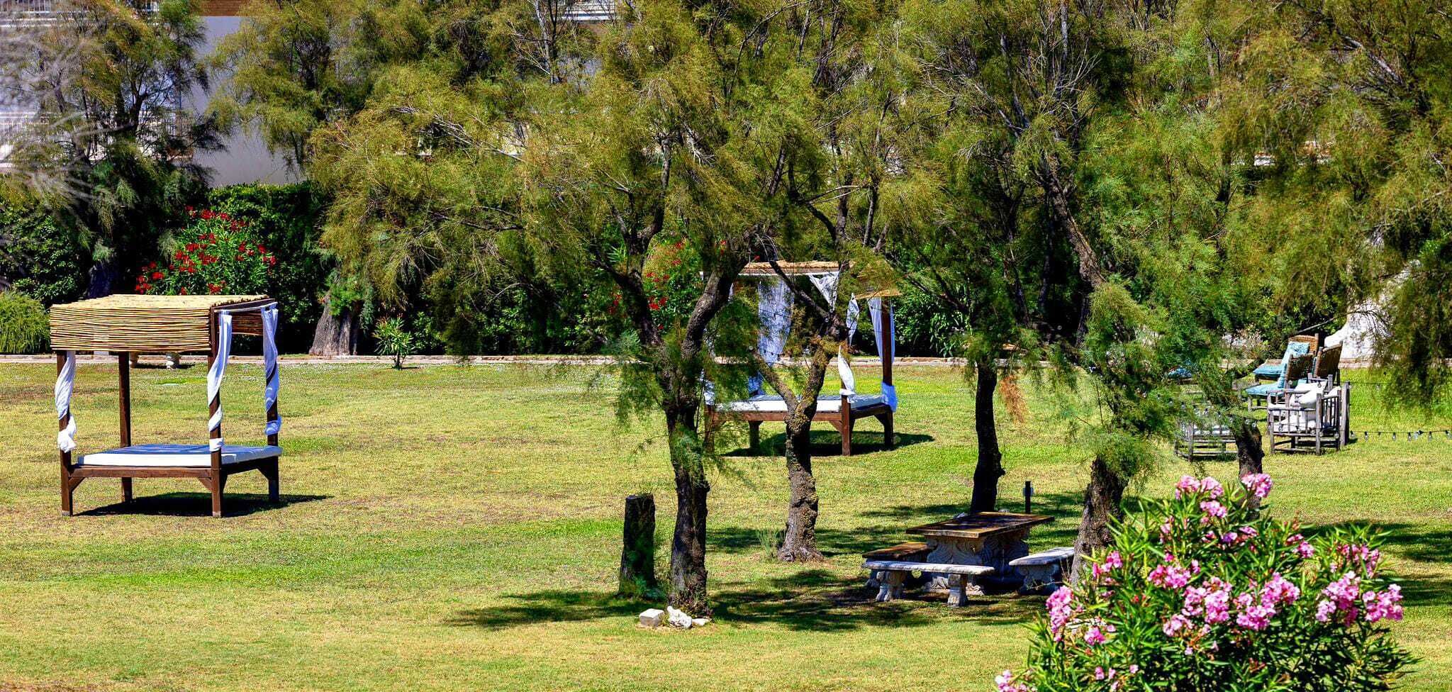 A park with outdoor seating areas, including a wooden bench and a swing set.