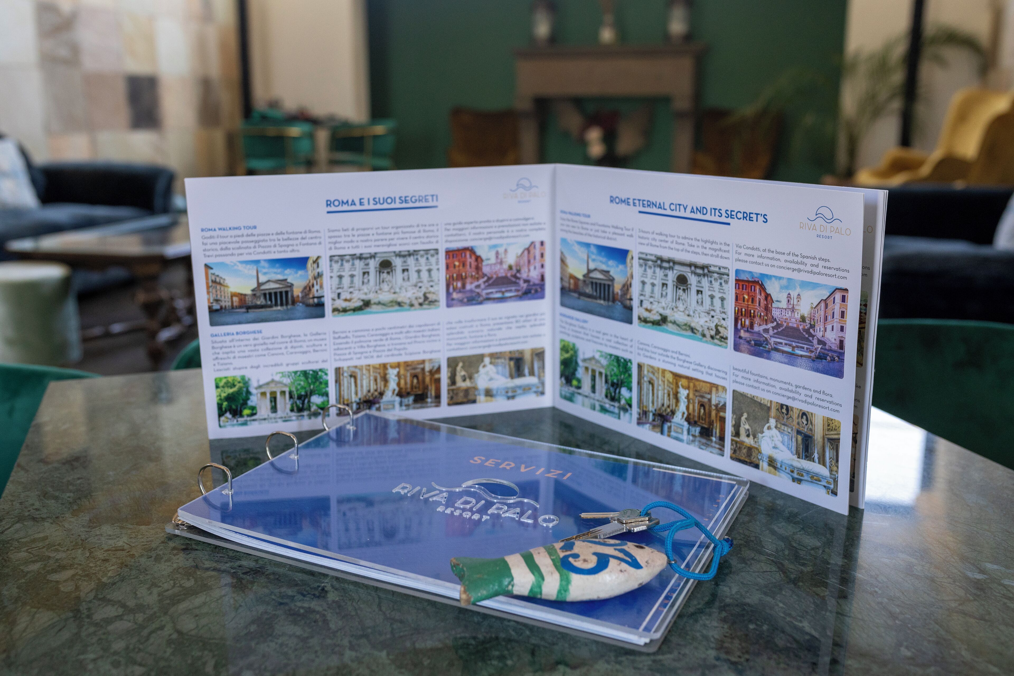 A brochure titled "Roma e i suoi segreti" on a table with a marble surface.