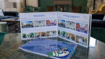 A brochure titled "Roma e i suoi segreti" on a table with a marble surface.