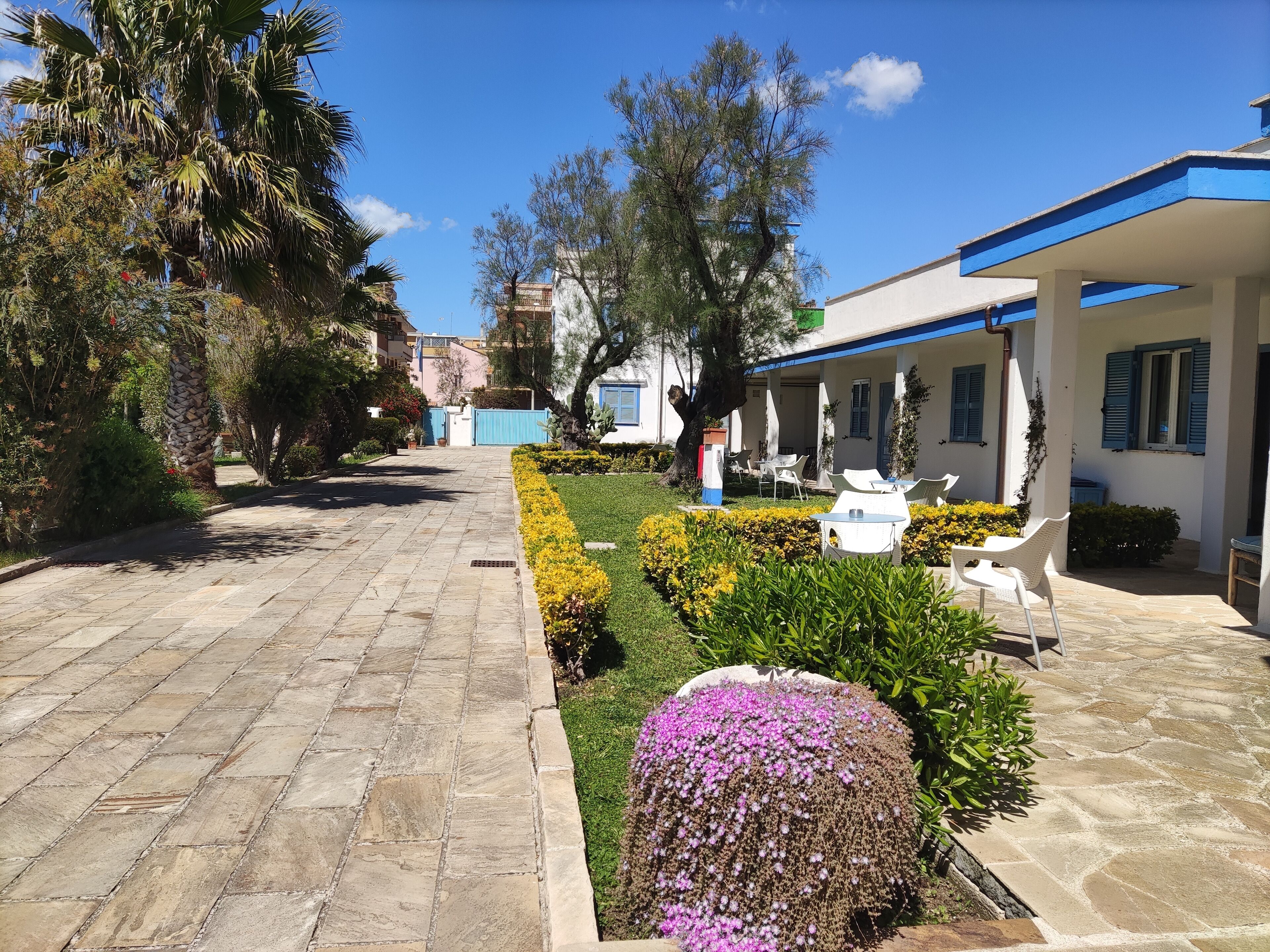 A paved pathway leading to a building with outdoor seating.