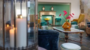 A cozy living room with a fireplace, comfortable seating, and a vase with flowers. - Riva di Palo Resort (Ladispoli)