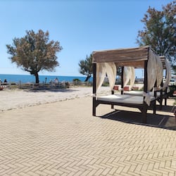 Privatstrand, schwarzer Sandstrand, Liegestühle, Sonnenschirme