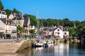 Une ville riveraine, avec des bâtiments, un pont et des bateaux amarrés le long de la berge.