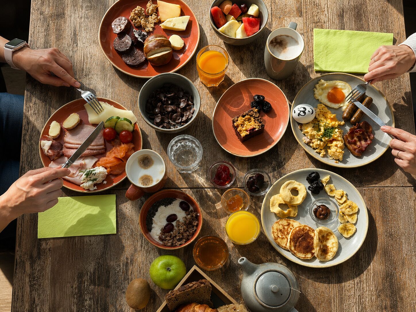 Una mesa de madera con diversos productos para el desayuno, incluyendo platos de comida, un hervidor y una taza de café.