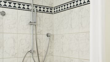 Un baño con ducha, bañera y retrete.