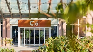 Entrada moderna de un edificio con puerta de vidrio y un cartel que dice 'Co 56 Chennitz'.