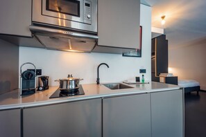 Una cocina moderna con microondas, estufa y lavaplatos incorporados.