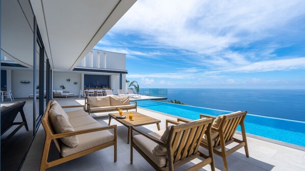 Un espacio moderno al aire libre con piscina y vista al océano.