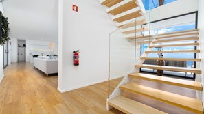 A modern interior with a staircase, a living area, and a kitchen.