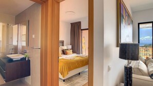 Une chambre d’hôtel moderne avec salle de bain, un lit donnant sur une vue agréable et un balcon.
