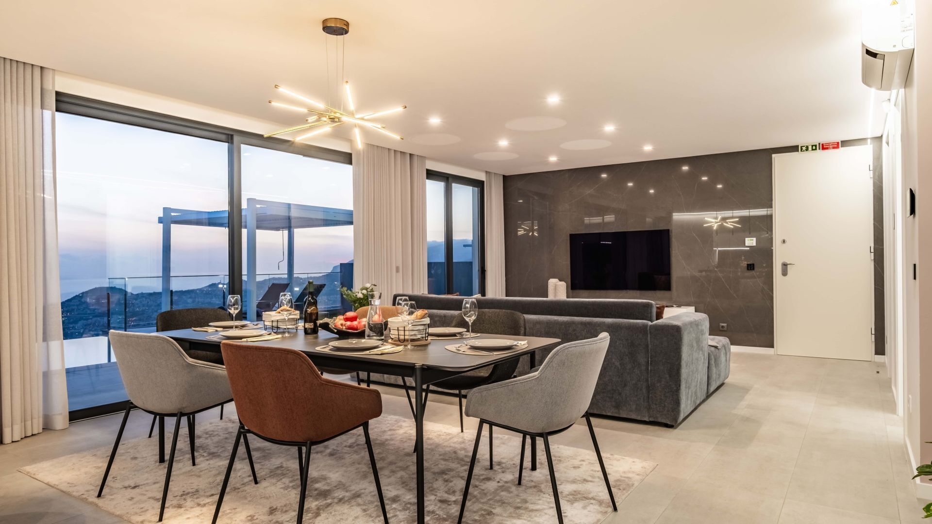 A modern dining area with a large table, chairs, and a city view.