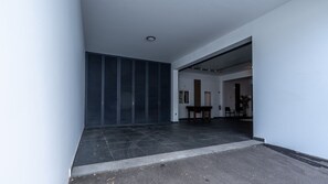 Un intérieur moderne avec un sol carrelé, une porte à volets fermés et une table entourée de chaises.