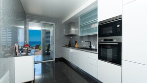 A modern kitchen with a view of the sea, a red toaster, and a Bosch oven. - Over the Cliff Apartment by LovelyStay (Funchal)