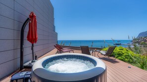 Ein Whirlpool auf einer Terrasse mit Blick aufs Meer.