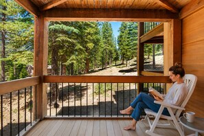 A wooden deck with a view of a forest.