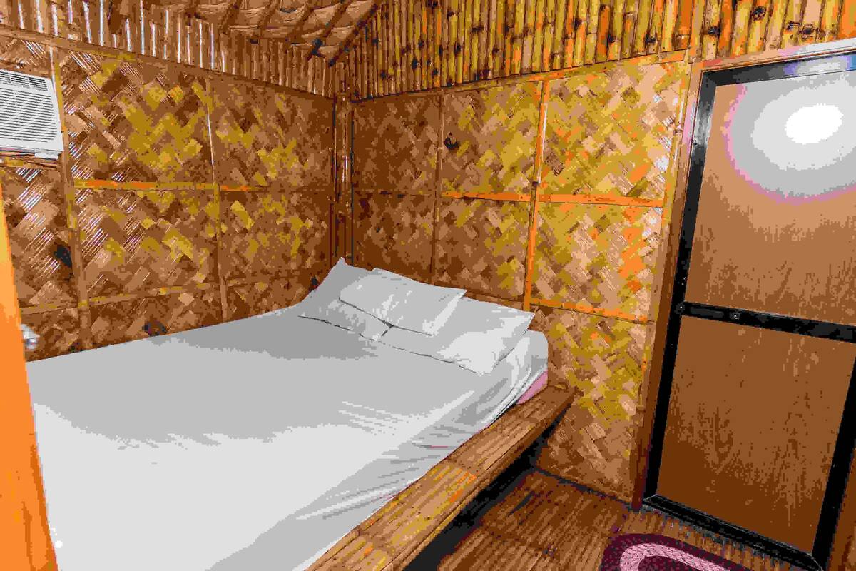 Ein Zimmer mit einem Bett, Holzwänden und einem Fenster.