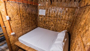 A single bed with white linens in a room with bamboo walls and a woven ceiling. - Villa Elizabeth Beach Resort (Lucena)