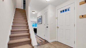A staircase leading to a room with a door, a window, and a ceiling light fixture.