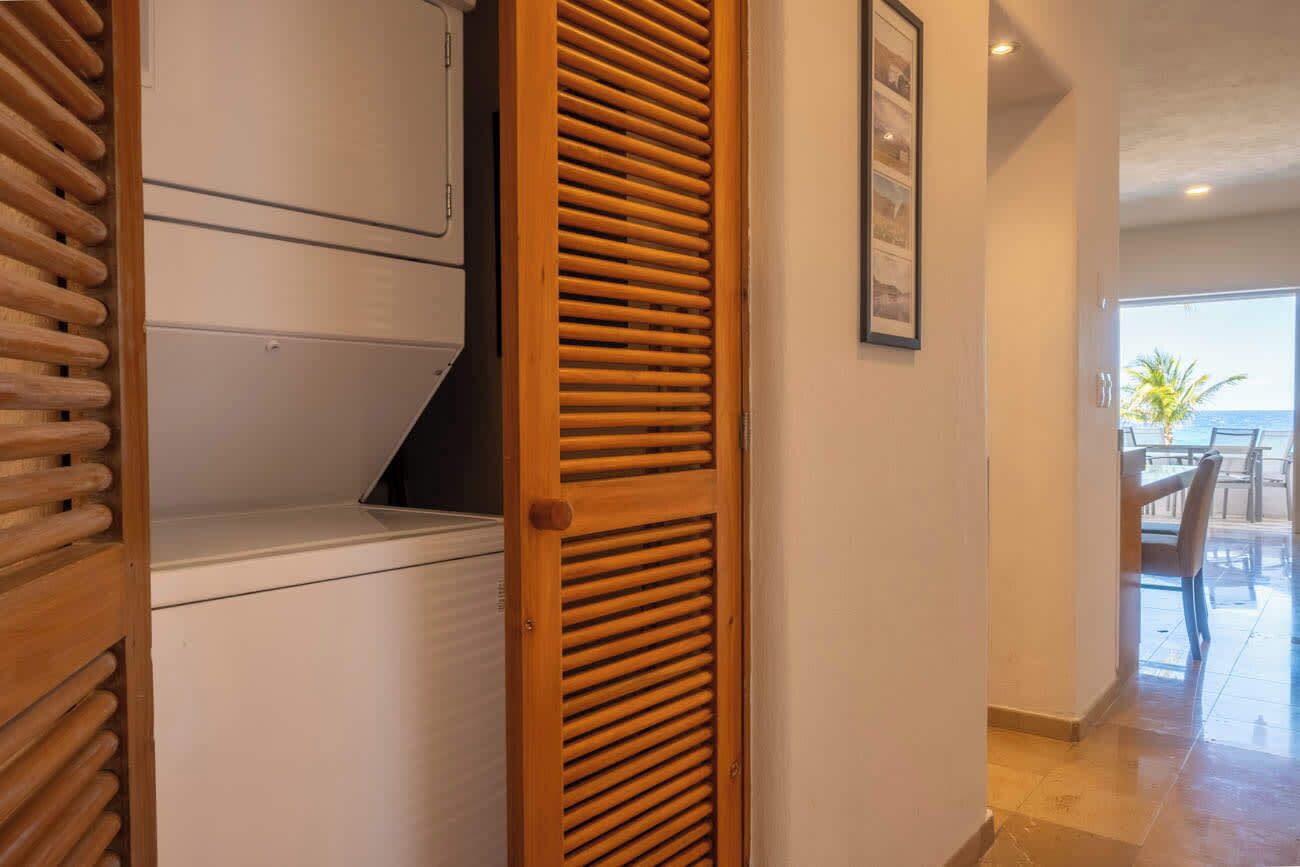 A hallway with a wooden door, a white cabinet, and a framed picture on the wall.