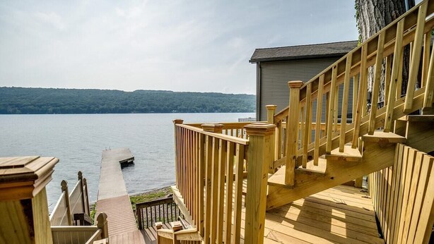 Une terrasse en bois offrant une vue sur un lac et un quai.