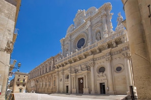 A grand historical building with intricate architectural details, large windows, and a prominent entrance.