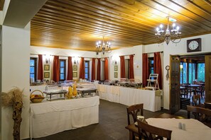 A dining area with multiple buffet tables, wooden ceiling, and a chandelier. - Kipi Mountain Resort (Zagori)