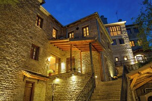 Un edificio de piedra con una escalera de madera y un balcón.