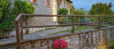 Un bâtiment en pierre doté d’une balustrade en bois et d’un escalier menant à l’entrée.