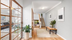 Een modern interieur met een trap, houten vloeren en een groot raam.