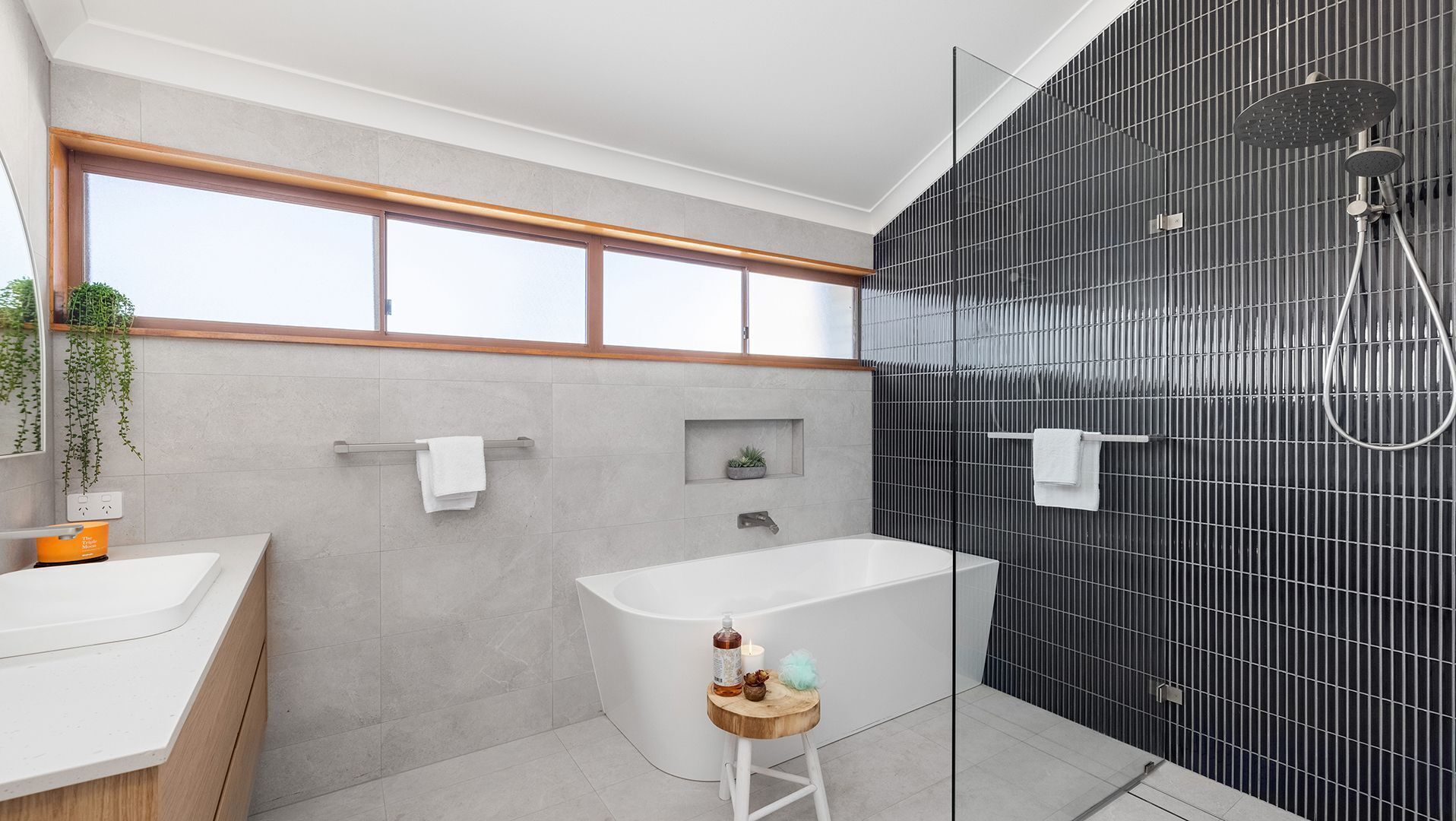 A modern bathroom with a bathtub, a shower, and a vanity with a sink.