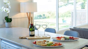 A dining table with a bottle of Moët & Chandon champagne, two wine glasses, and a variety of food including bread, vegetables, and meats.