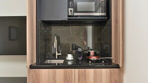 A compact kitchen with a microwave, sink, and stove. - Opal Lofts - Quartier Latin (Montreal)