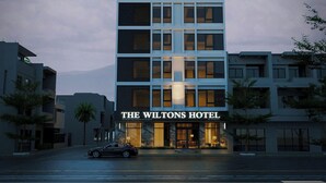 A modern hotel building with a prominent entrance and a car parked in front. - THE WILTONS HOTEL LAO CAI (Lao Cai)