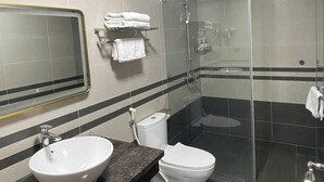 A modern bathroom with a glass shower enclosure, a white sink, and a toilet. - THE WILTONS HOTEL LAO CAI (Lao Cai)