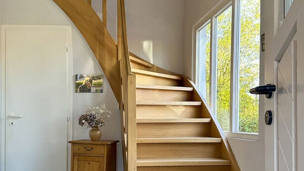 A wooden staircase leading to a landing with a door and a window. - Idyllic fisherman's house, modern and friendly, close to the beach (Varel)