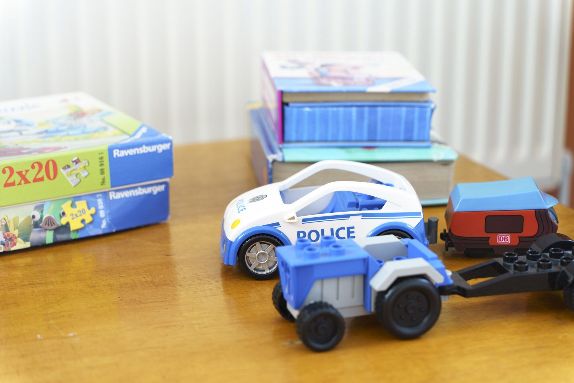 Une voiture de police jouet et un camion jouet sur une table en bois.