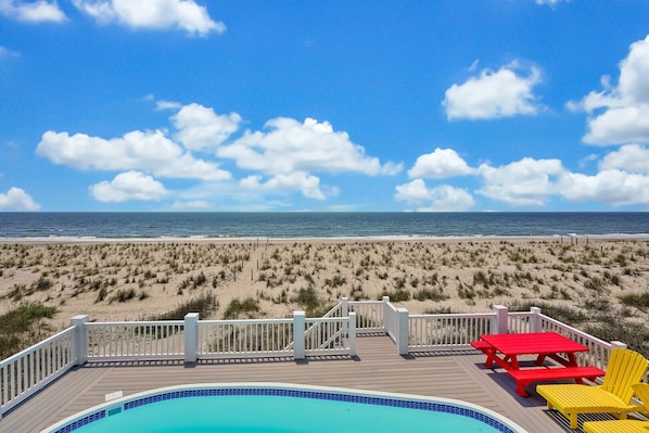 A beach view with a pool and deck area.