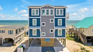A multi-story beachfront building with a balcony, a beach view, and a sign indicating 'Oceanview'. - BonBini: Oceanfront 7-bedroom house in Oak Island, perfect for large groups. (Oak Island)