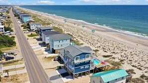 A beachfront property with multiple buildings, a road, and a beach. - BonBini: Oceanfront 7-bedroom house in Oak Island, perfect for large groups. (Oak Island)