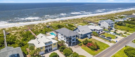 A coastal residential area with houses, a road, and a beach.