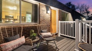 A cozy outdoor seating area with wicker furniture and a stone wall. - Cozy Denver Stay | Grill + Patio | Sloan’s Lake| Firepit (Denver)