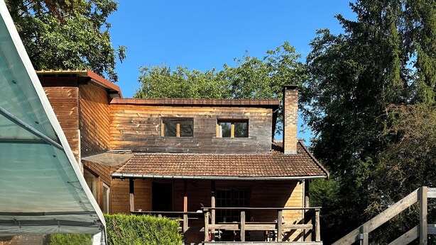 Una casa de madera con una piscina delantera.