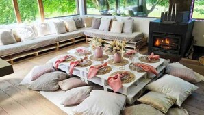 Una sala de estar acogedora con un sofá, una chimenea y un comedor listo para una comida.